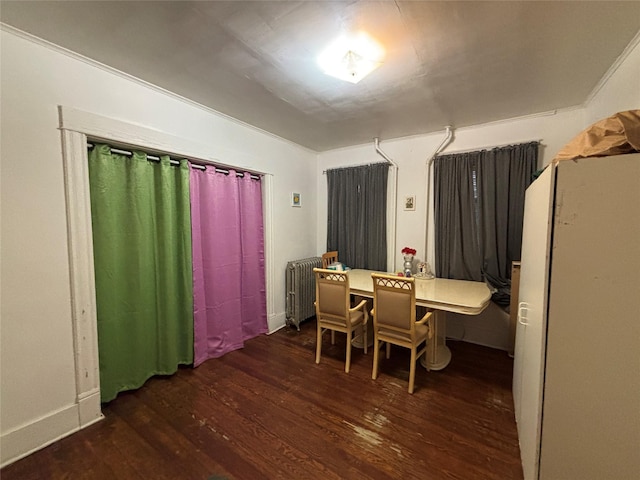 dining area with dark hardwood / wood-style flooring and radiator