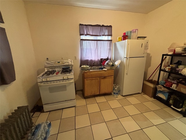 kitchen featuring white appliances, sink, and light tile patterned floors