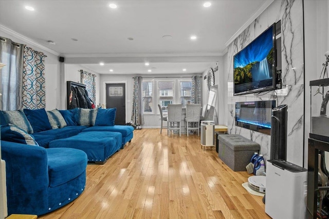 living room featuring crown molding, a fireplace, and light hardwood / wood-style flooring