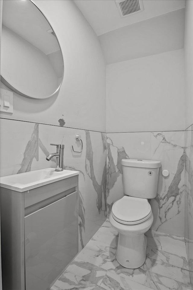 bathroom with vanity, lofted ceiling, and toilet