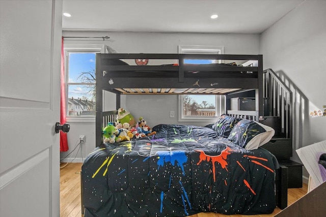 bedroom with multiple windows and hardwood / wood-style flooring