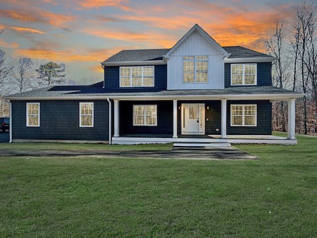 view of front of home featuring covered porch and a lawn