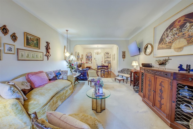 living room featuring ornamental molding, light carpet, and a notable chandelier