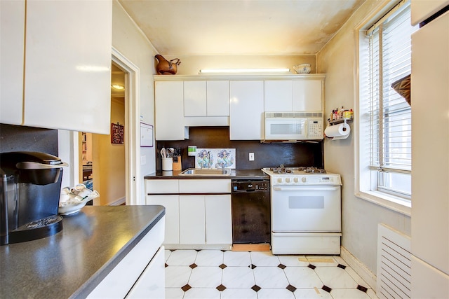 kitchen with sink, white cabinets, and white appliances