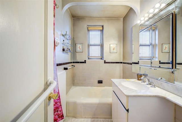 bathroom with vanity, a wealth of natural light, and a tub to relax in