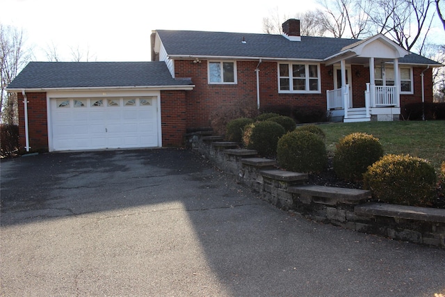 ranch-style house featuring a garage and covered porch