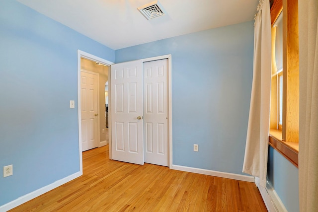 unfurnished bedroom featuring a closet and light wood-type flooring