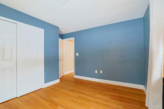 unfurnished bedroom featuring wood-type flooring and a closet