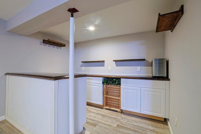 kitchen with light hardwood / wood-style flooring and white cabinets