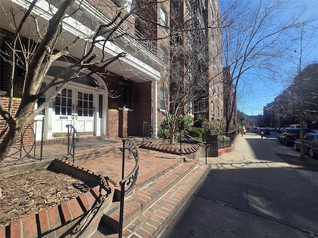 property entrance featuring french doors and brick siding