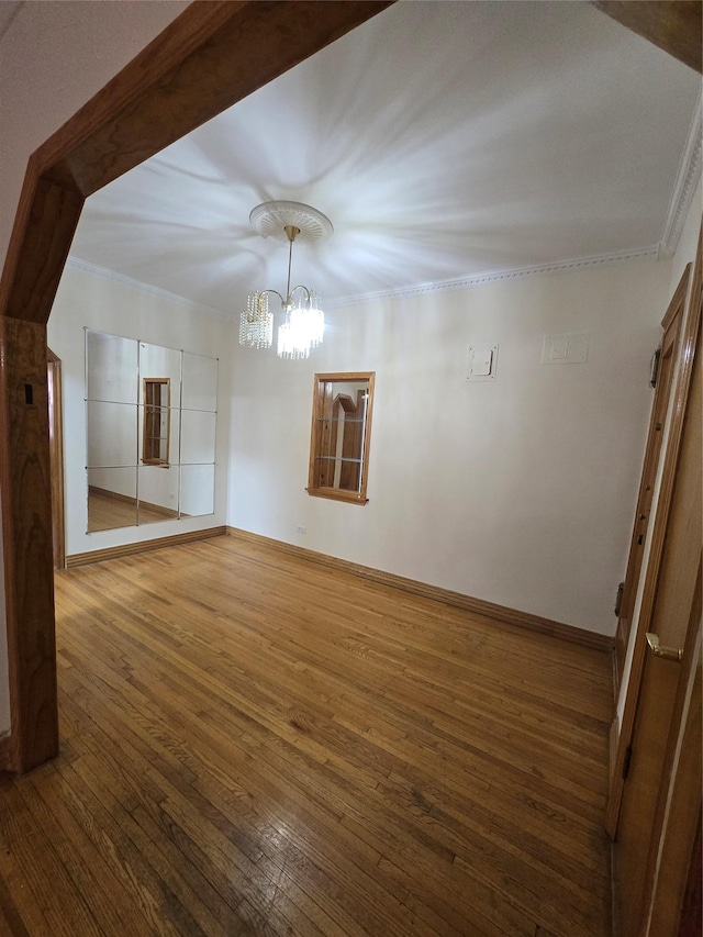bonus room featuring hardwood / wood-style flooring, baseboards, and an inviting chandelier