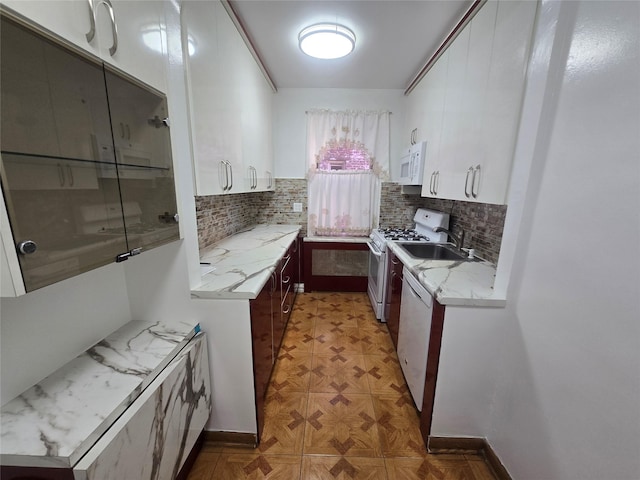 kitchen featuring tasteful backsplash, white appliances, and white cabinets