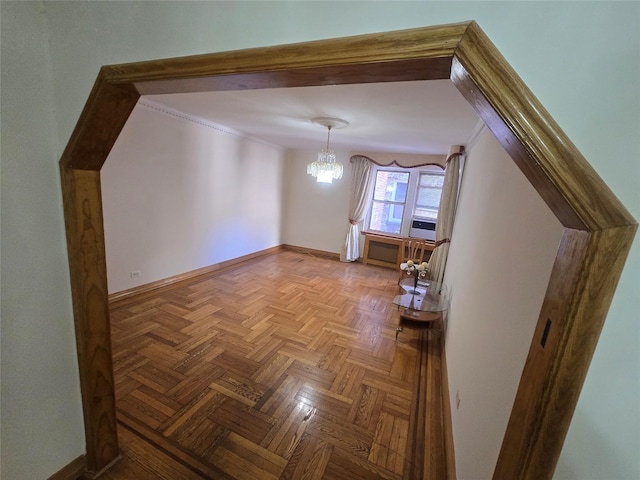 additional living space with an inviting chandelier and baseboards