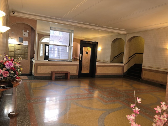 interior space with arched walkways, ornamental molding, and mail area