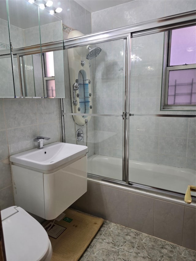 bathroom featuring tiled shower / bath, toilet, backsplash, and tile walls