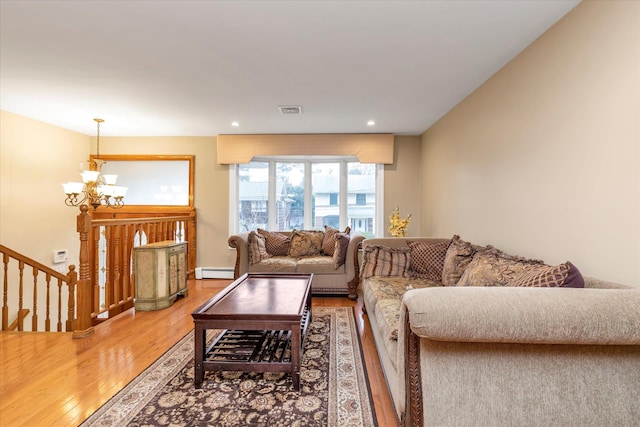 living room with an inviting chandelier, hardwood / wood-style floors, and baseboard heating