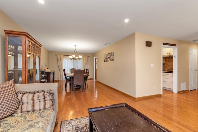 dining space with a notable chandelier and light hardwood / wood-style flooring