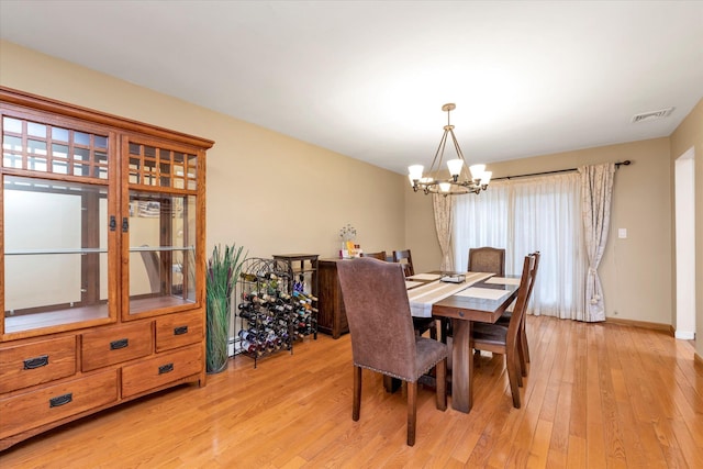 dining room featuring an inviting chandelier and light wood-type flooring