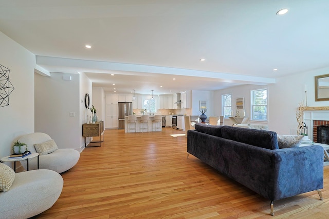 living room with a fireplace and light wood-type flooring