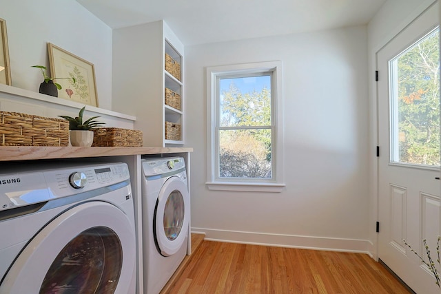 laundry room with independent washer and dryer, plenty of natural light, and light hardwood / wood-style floors