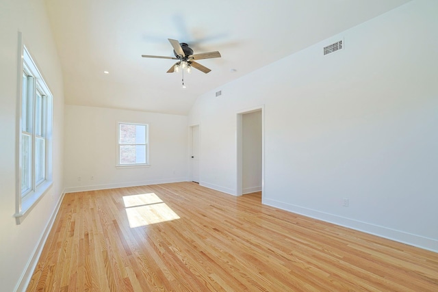 empty room with ceiling fan, vaulted ceiling, and light wood-type flooring