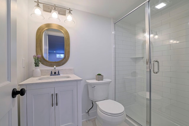 bathroom with vanity, toilet, and a shower with shower door