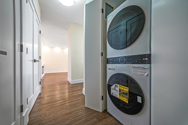 laundry room with stacked washing maching and dryer and dark hardwood / wood-style flooring