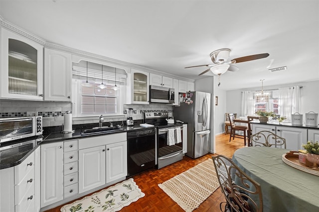 kitchen featuring dark parquet flooring, sink, white cabinetry, appliances with stainless steel finishes, and backsplash