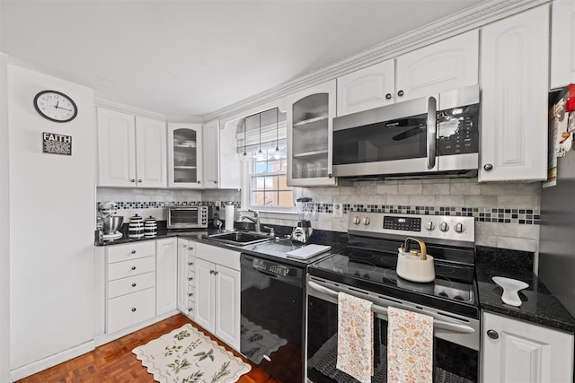 kitchen featuring appliances with stainless steel finishes, white cabinetry, sink, parquet floors, and backsplash