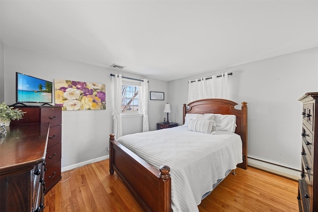 bedroom featuring a baseboard radiator and light wood-type flooring