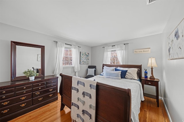 bedroom with multiple windows and hardwood / wood-style floors