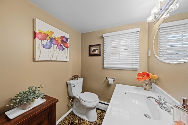 bathroom with vanity, baseboard heating, and toilet