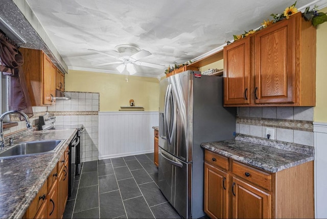 kitchen featuring sink, ornamental molding, dark stone counters, and appliances with stainless steel finishes