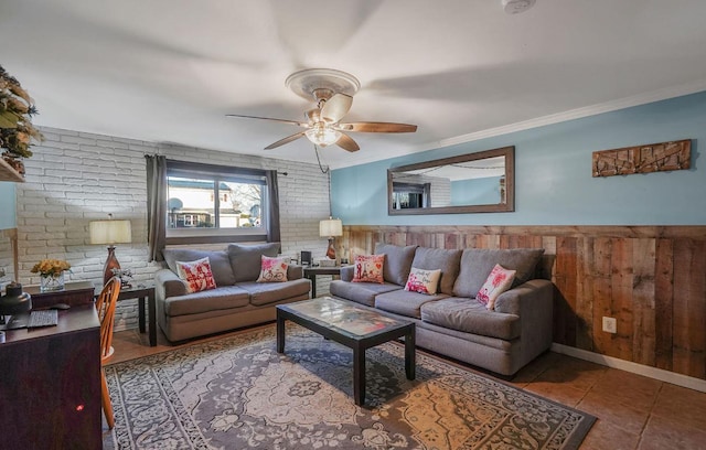 living room featuring light tile patterned floors, crown molding, ceiling fan, brick wall, and wood walls