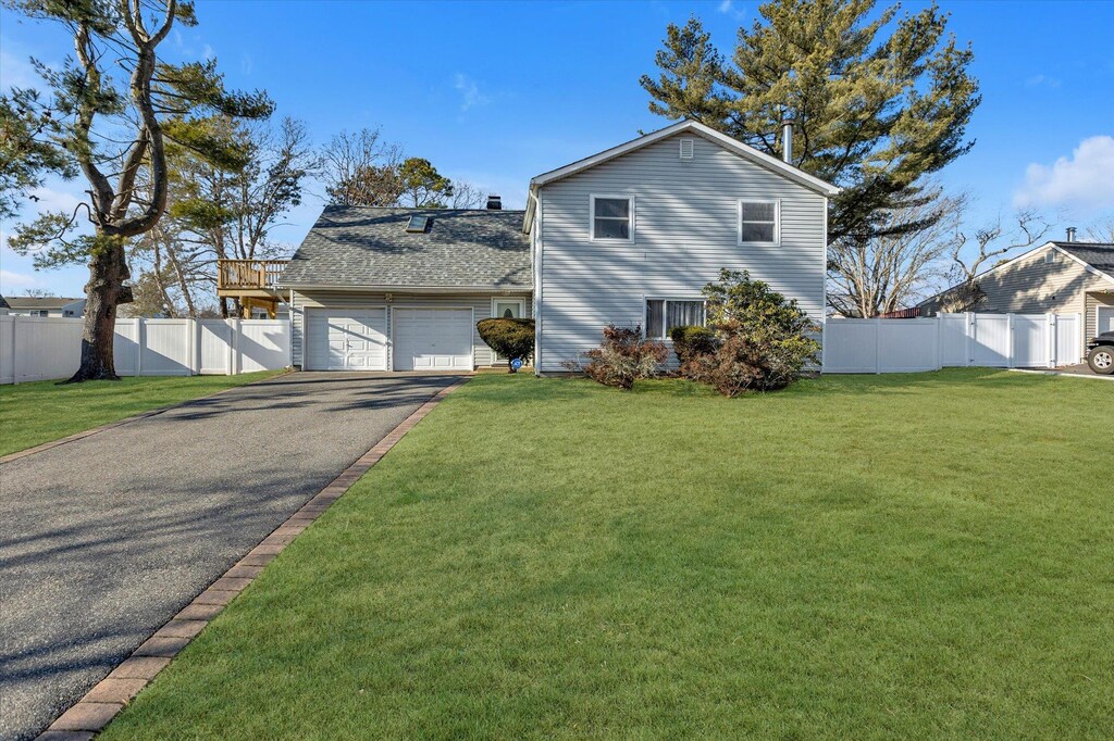 26 Clusterpine St, Medford, NY 11763 - view of front of house with a garage and a front lawn