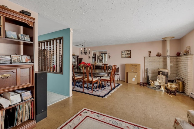 interior space with a wood stove, a textured ceiling, and a notable chandelier