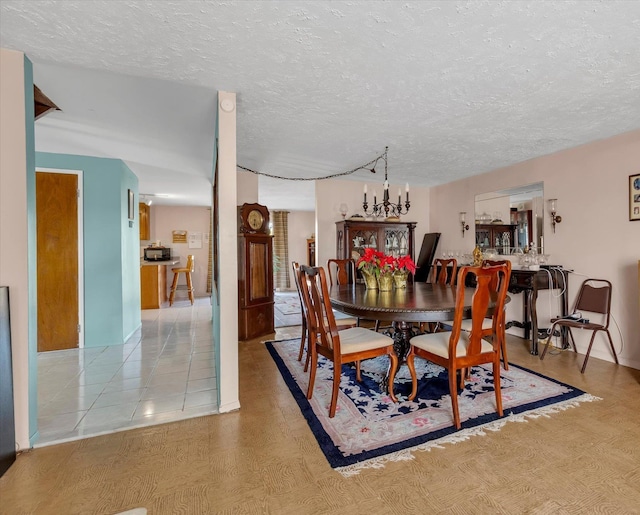 dining area with a notable chandelier and a textured ceiling