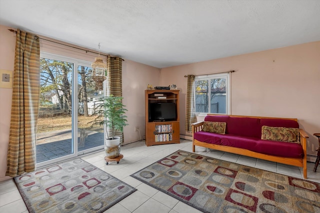 tiled living room featuring a baseboard radiator and a textured ceiling