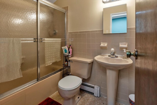 full bathroom featuring toilet, sink, tile walls, a baseboard radiator, and enclosed tub / shower combo