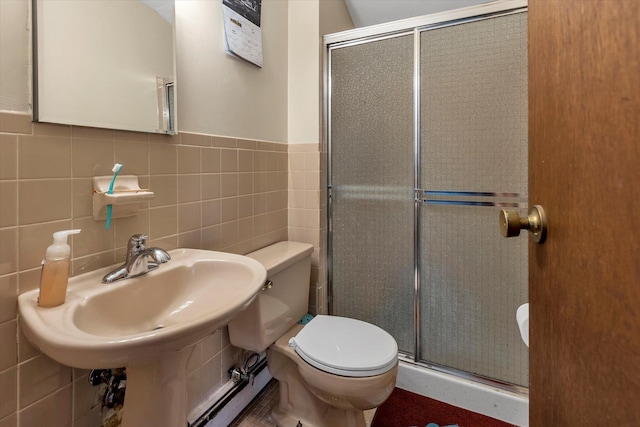 bathroom with toilet, sink, tile walls, and walk in shower