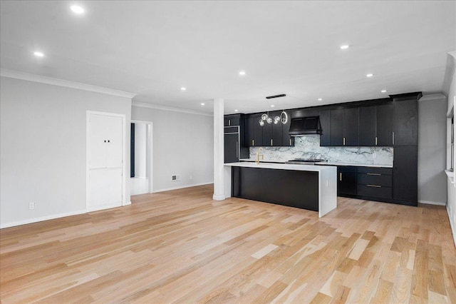 kitchen with tasteful backsplash, decorative light fixtures, range hood, and light hardwood / wood-style floors