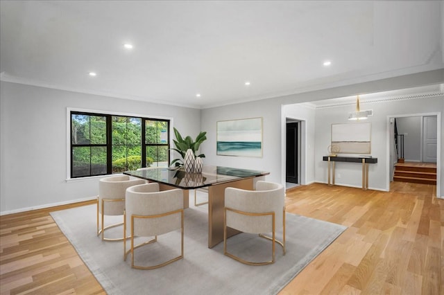 dining room featuring ornamental molding and light hardwood / wood-style flooring