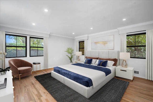 bedroom with ornamental molding and light hardwood / wood-style flooring