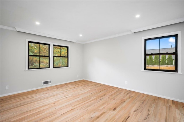 empty room with light hardwood / wood-style flooring and ornamental molding