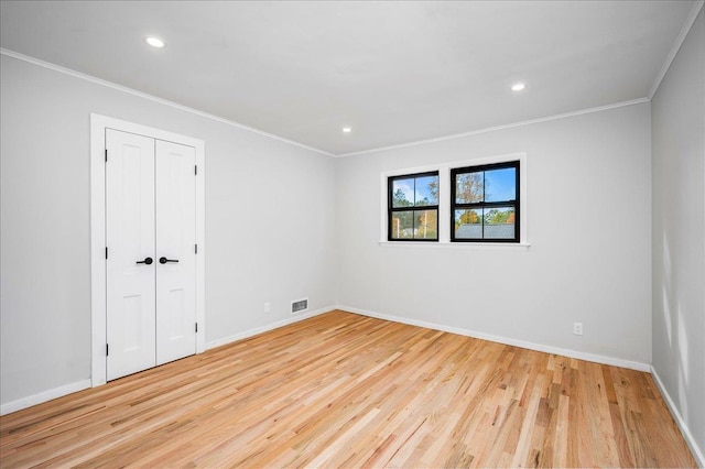 empty room featuring ornamental molding and light hardwood / wood-style floors