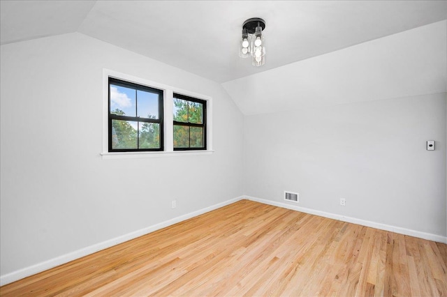 additional living space with lofted ceiling and light hardwood / wood-style floors