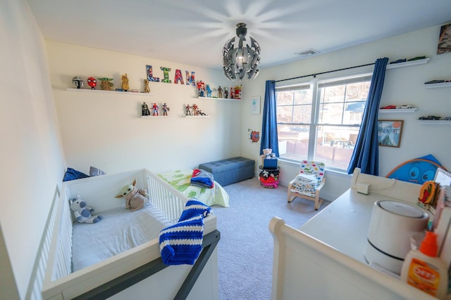 carpeted bedroom featuring an inviting chandelier