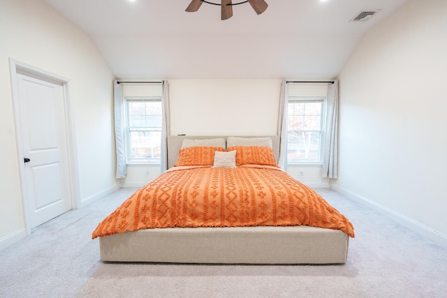 unfurnished bedroom with multiple windows, lofted ceiling, and light colored carpet