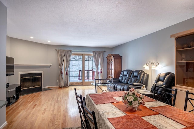 dining room featuring light hardwood / wood-style floors and a textured ceiling