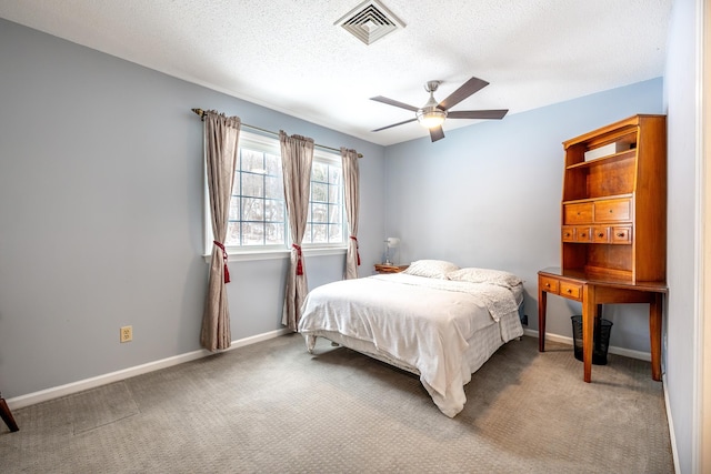 bedroom with ceiling fan, carpet, and a textured ceiling